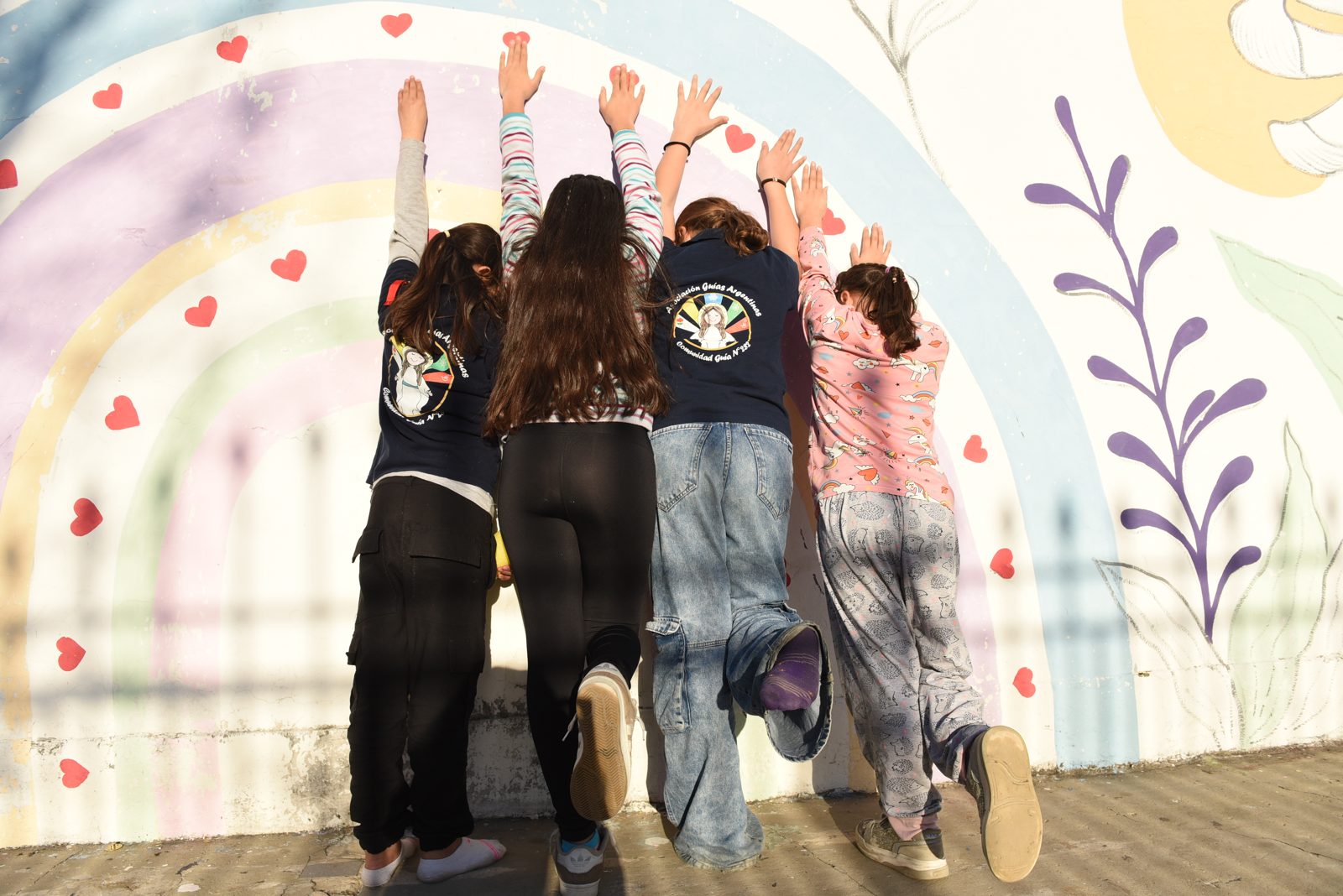 Niñas junto al mural del Hogar
